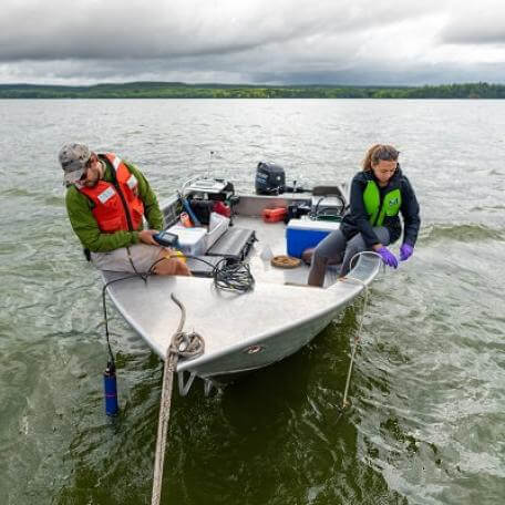 Graduate students on a boat conducting water sampling