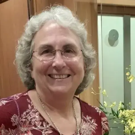 Sue in a maroon floral blouse.