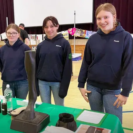 three hippology 4-h'ers at an exhibit table