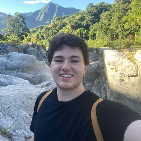Ryan standing in front of mountains and forests.