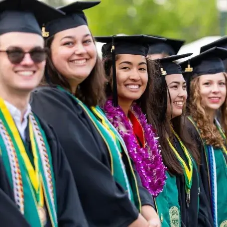 students in regalia at commencement.