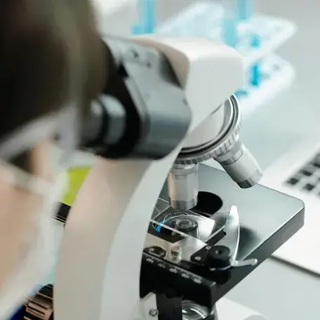 close-up of a person looking through a microscope