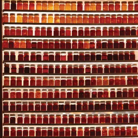 many shelves filled with small jars of maple syrup