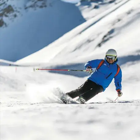 a skier slaloming down a snowy mountain