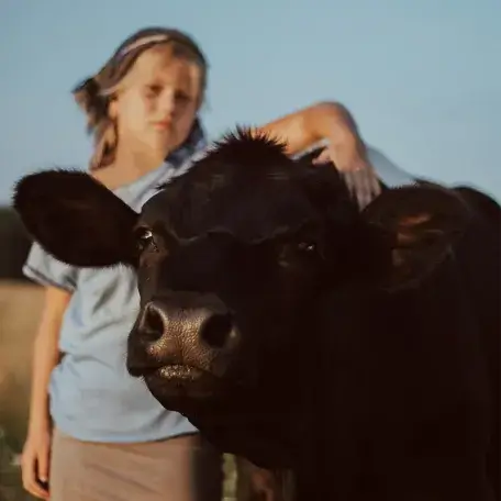 young person hugging a cow