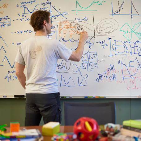 Professor writing on a white board