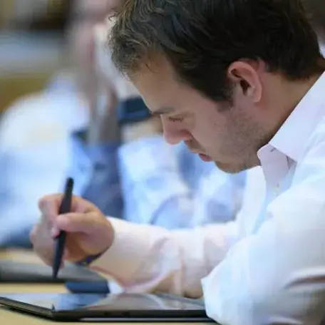 Adult learner writing on tablet