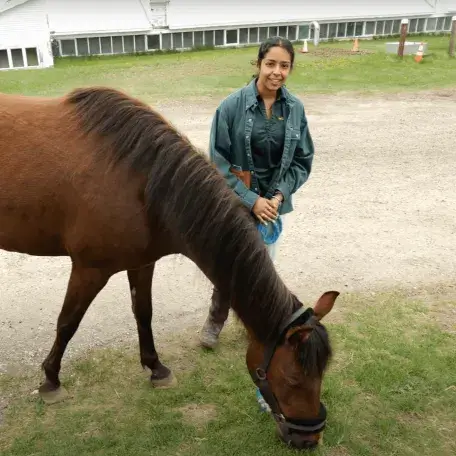 Smiling girl leading a horse