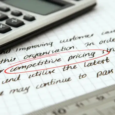 a piece of paper with marketing-speak written on it, under a calculator and a ruler