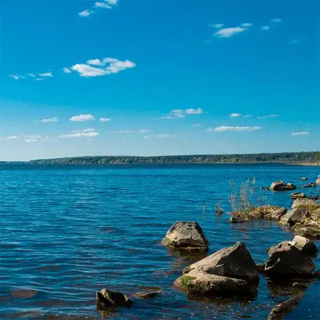 lake under clear skies with low mountains in the background