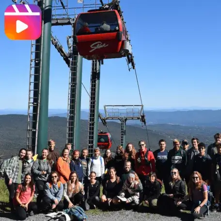 Class of students poses in front of the mount mansfield gondola at Stowe resort