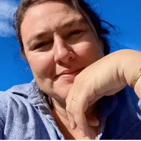 Ryun, sun shining on her smiling face with clouds and blue sky background