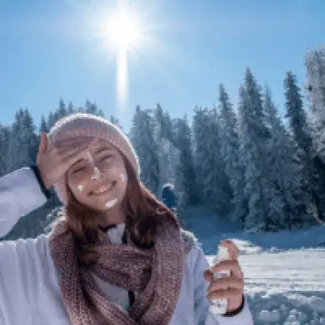 Teen applying sunscreen on a sunny day in winter