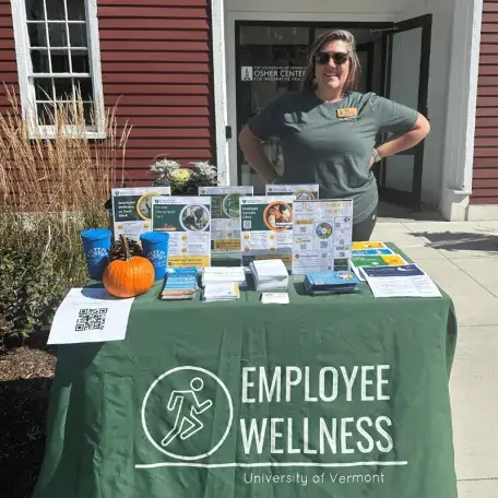 Cara Hancy sanding at a table of flyers and information