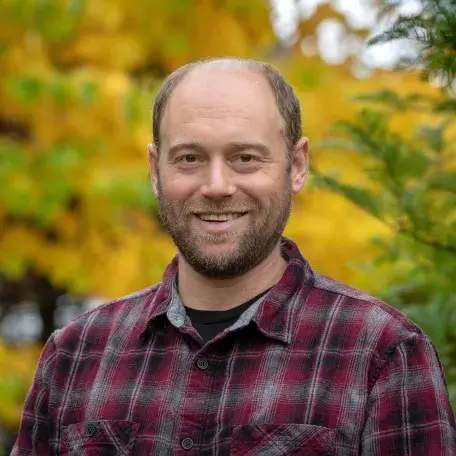 Headshot of Eric Bishop von Wettberg in plaid shirt in front of yellow trees