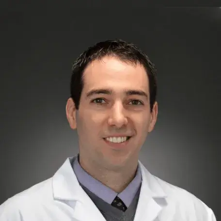 Researcher smiling posed against a grey background