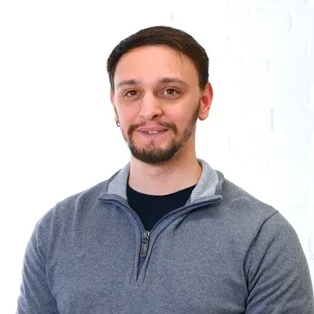 Man in a grey shirt on a white wall