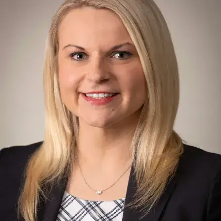 A person wearing a black jacket and a necklace