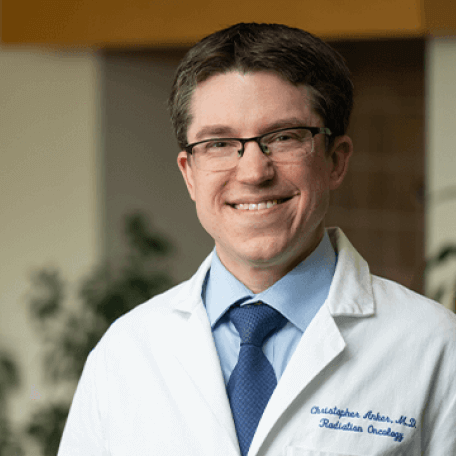 a man in a white coat smiling