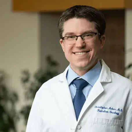 a man in a white coat smiling