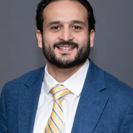 A person in a blue blazer and a yellow striped tie