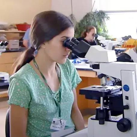 teenager looking into a microscope