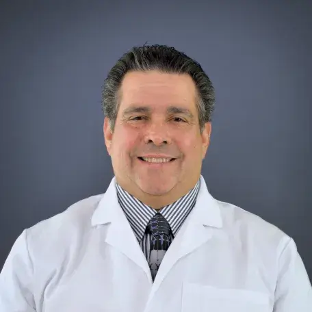 A person wearing a white coat and a tie