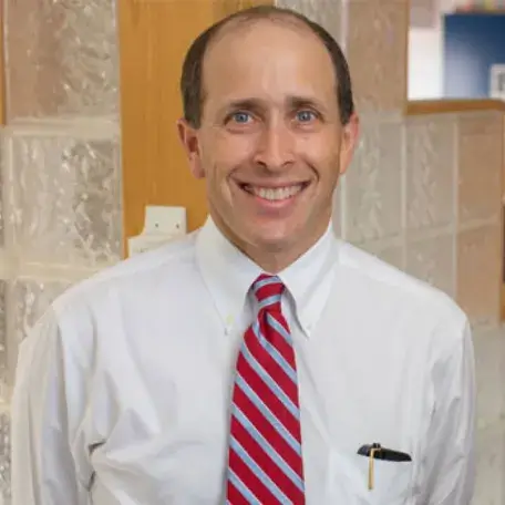 A person wearing a white shirt and a red striped tie