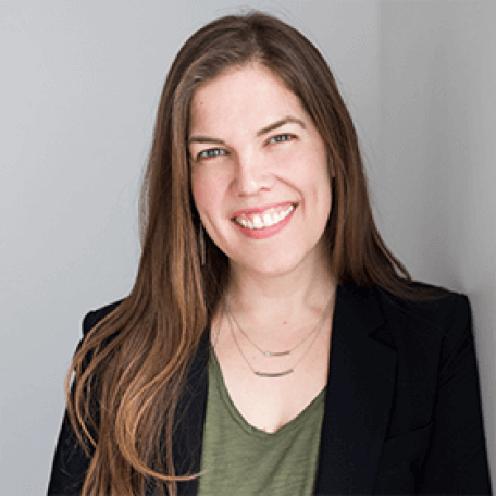 A person wearing a green shirt and a black blazer