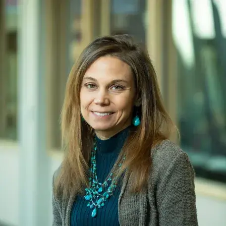 A person wearing a blue shirt and a gray cardigan