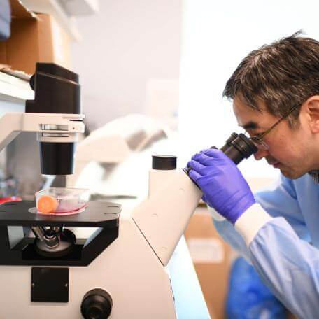 Ben Lee looking through microscope