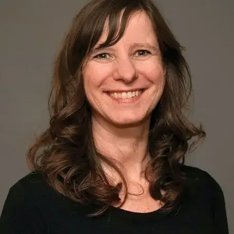 A person with brown hair wearing a black shirt