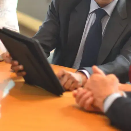 close up of hands of several people working at a laptop