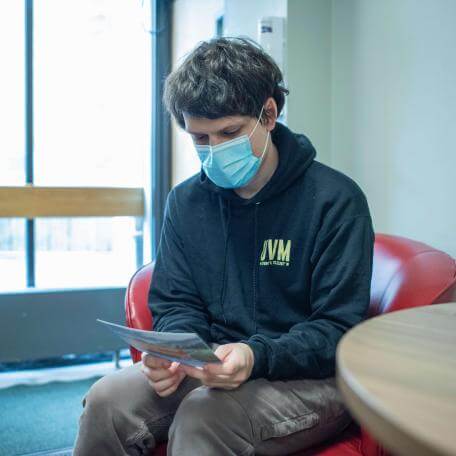 Max Stieglitz reading medical document in SHS waiting room