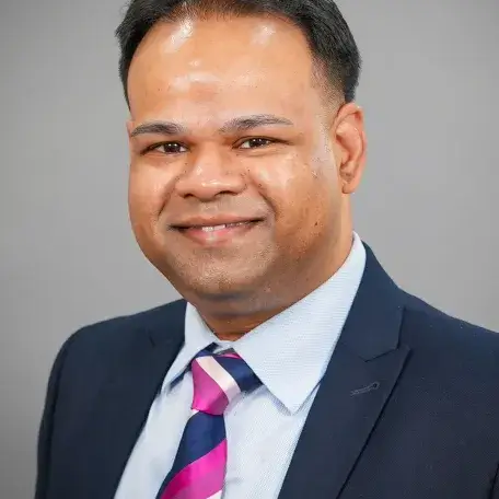 A person wearing a blazer and a purple striped tie