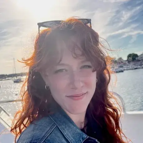 a woman with long wavy red hair on a boat