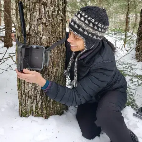 Lori Anderson inspecting a trail camera