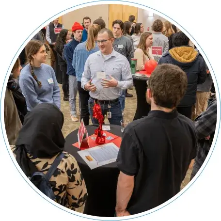 UVM students meet an alum at a table at the STEM Networking night