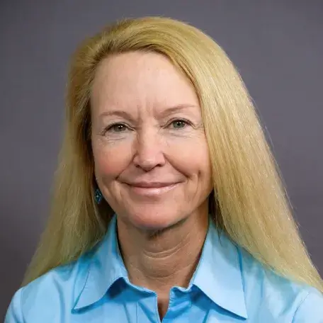 light skinned woman with shoulder length blonde hair wearing a light blue collared shirt