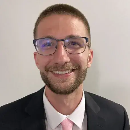 A person wearing glasses and a blazer
