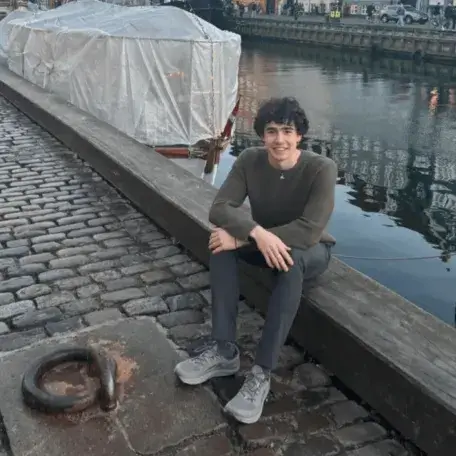 A young man sitting next to a European Canal