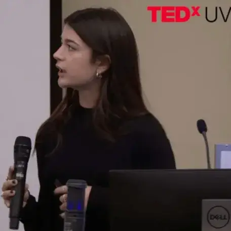 A young woman giving a TedX UVM talk