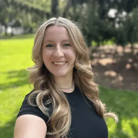 A headshot of a woman with long blonde hair wearing a black shirt.