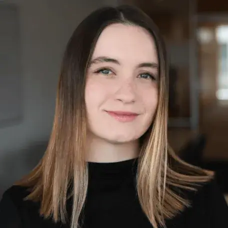 A headshot of a woman with short brown hair wearing a black shirt.