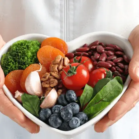 Person holding a bowl with fruit and vegetables