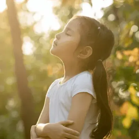 child with their face up to the sun