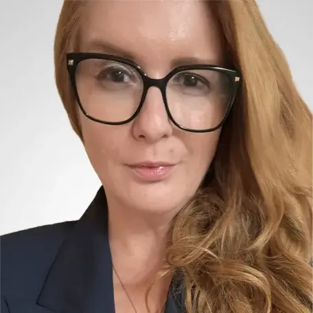 Photo of Alena Demirovic, she is wearing glasses, she has red hair.
