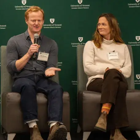 L to R: Chris Stimpson (’16) and Courtney Crowley (’15) sit on stage while Chris speaks into a microphone