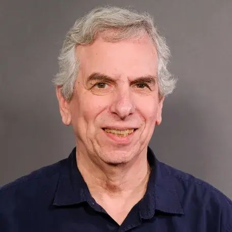 grey haired man with dark blue shirt