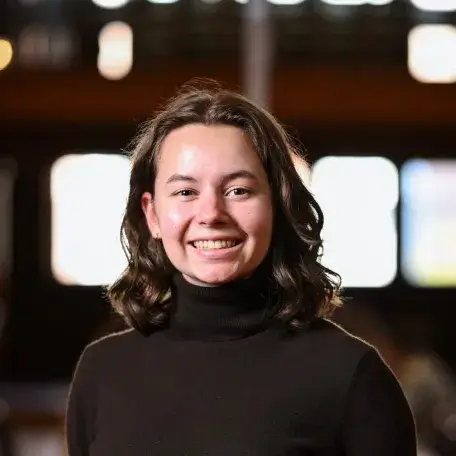 Smiling person wearing a brown turtleneck